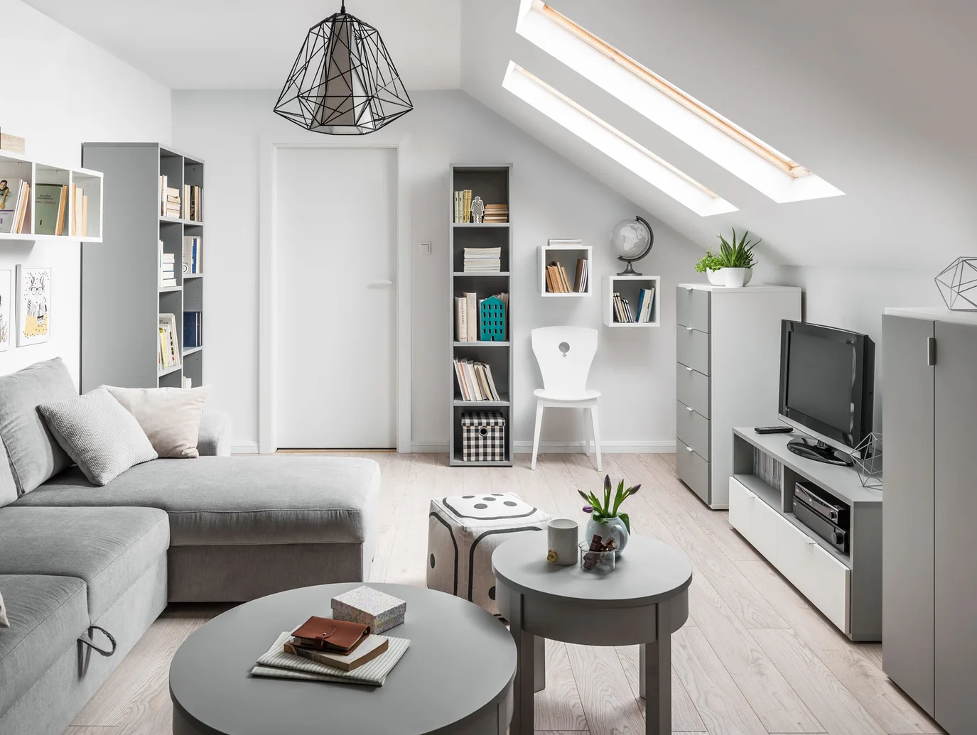 Stylowy salon na poddaszu z dużą ilością naturalnego światła.